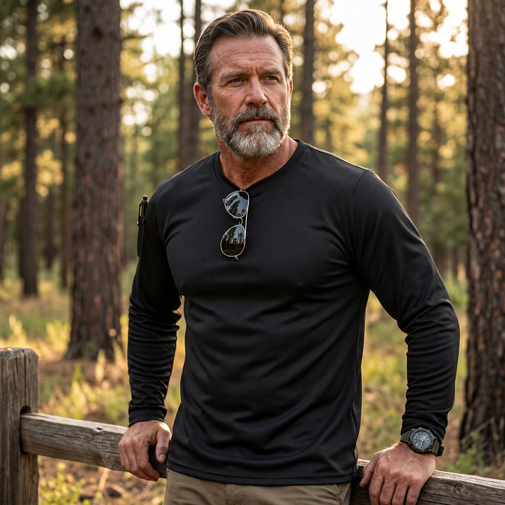 Black long-sleeve outdoor shirt with plain sleeve shown on a forest walk