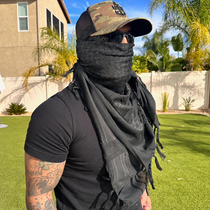 black shemagh scarf worn outdoors with plain clothing